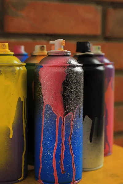 Used Cans Spray Paints Table Brick Wall Closeup Graffiti Supplies — Stock Photo, Image