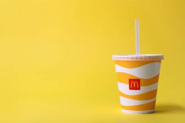 MYKOLAIV, UKRAINE - 12 Ağustos 2021: sarı arka planda soğuk McDonald 's içeceği. Metin için boşluk