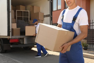 İşçiler açık hava minibüsünden kutuları boşaltıyor. Taşıma servisi