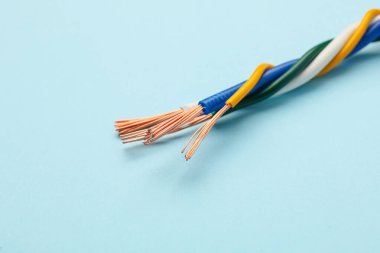 Açık mavi arkaplanda birçok soyulmuş elektrik kablosu, yakın plan