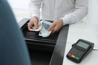 Bankada parası olan bir kasiyer, yakın plan. Para birimi değişimi