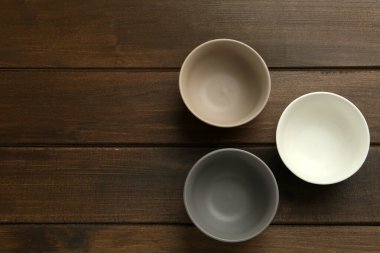 Ahşap masadaki boş seramik kaseler, düzlük ve yazı için boşluk. Mutfak aletleri