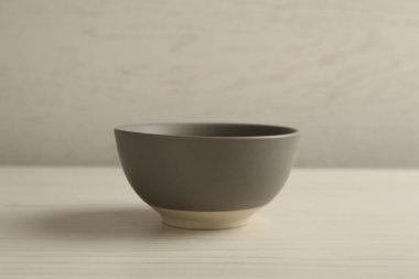 Beyaz ahşap masada boş seramik kâse. Mutfak aletleri