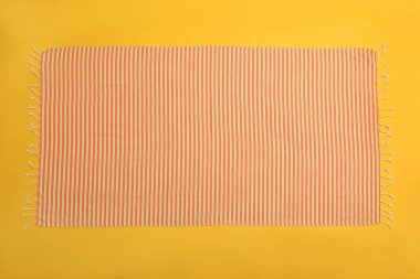 Sarı arka planda çizgili plaj havlusu, üst manzara.