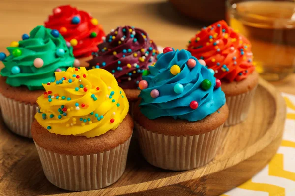 Deliciosos Cupcakes Con Crema Colores Espolvoreos Sobre Tabla Madera Primer — Foto de Stock