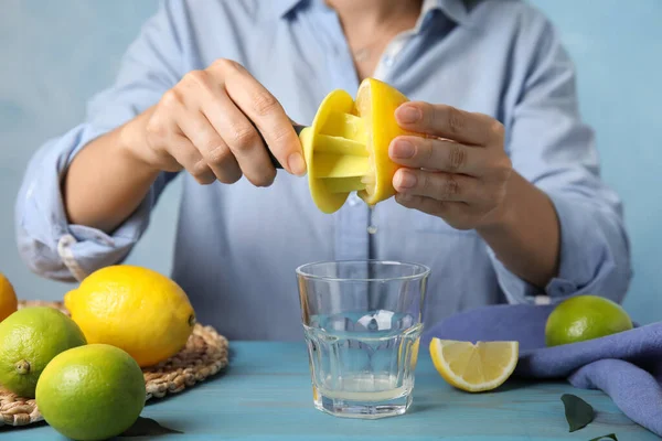 Mujer Exprimiendo Jugo Limón Con Escariador Cítricos Mesa Madera Azul — Foto de Stock