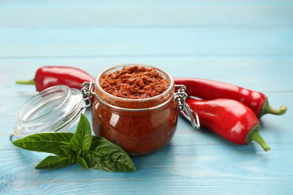 Köstliche Adjika Sauce Glas Und Zutaten Auf Hellblauem Holztisch — Stockfoto