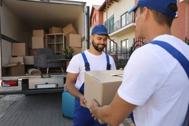 İşçiler açık hava minibüsünden kutuları boşaltıyor. Taşıma servisi
