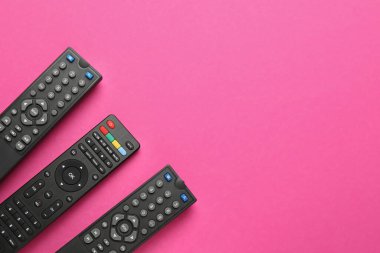 Pembe arka planda uzaktan kumanda, düz konum. Metin için boşluk
