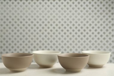 Beyaz ahşap masada boş seramik kaseler, yazı için yer. Mutfak aletleri