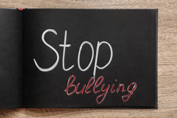 Texto Stop Bullying Escrito Notebook Preto Mesa Madeira Vista Superior — Fotografia de Stock