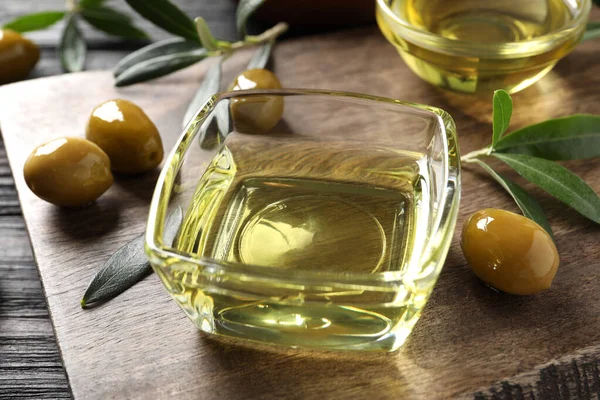 Cuencos Vidrio Aceite Aceitunas Maduras Hojas Verdes Sobre Mesa Madera —  Fotos de Stock