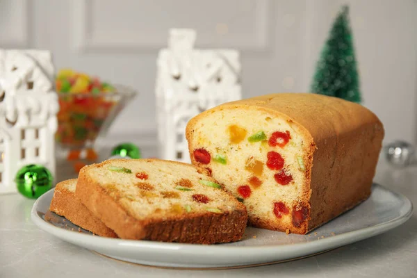 薄緑色のテーブルの上に砂糖漬けの果物やクリスマスの装飾とおいしいケーキ — ストック写真