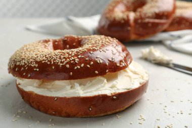 Işık masasında krem peynirli leziz simit, yakın plan.