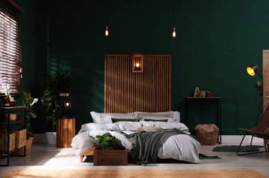 Geniş konforlu yatağı ve saksısı olan şık bir iç mekan.