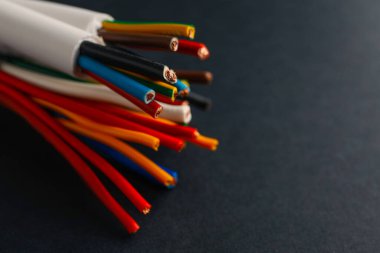 Siyah arka planda birçok elektrik kablosu var, yakın plan. Metin için boşluk