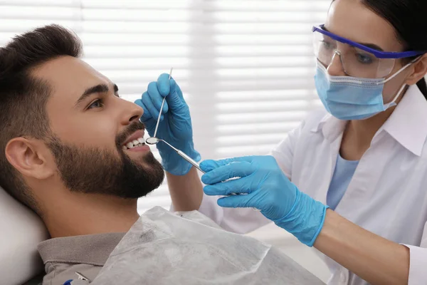 Zubař Vyšetřující Zuby Mladého Muže Moderní Klinice — Stock fotografie