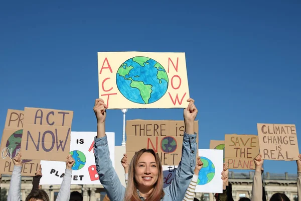 屋外の気候変動に抗議するポスターを持つ人々のグループ — ストック写真