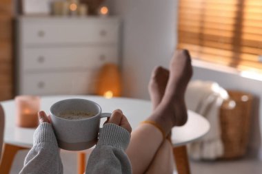 Bir fincan aromatik kahveli kadın evde dinleniyor, yakın plan.