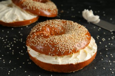 Siyah masada krem peynirli leziz simit, yakın plan.