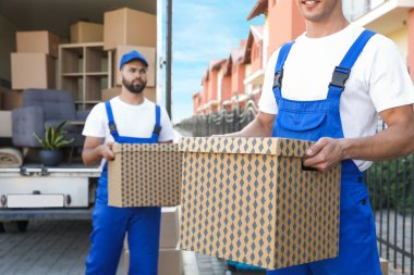 İşçiler açık hava minibüsünden kutuları boşaltıyor. Taşıma servisi