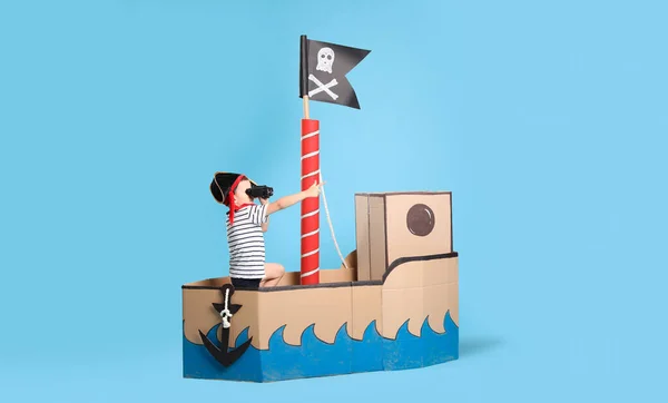 Μικρό Αγόρι Παίζει Κυάλια Πειρατικό Χαρτόνι Πλοίο Τυρκουάζ Φόντο — Φωτογραφία Αρχείου