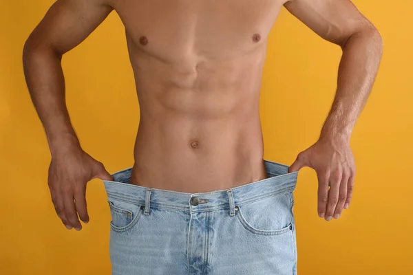 Shirtless Man Med Smal Kropp Bär Stora Jeans Gul Bakgrund — Stockfoto