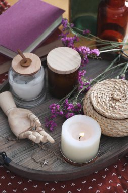 Masada süslemeleri ve kitapları olan tahta tepsi.