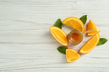 Portakal reçeli kavanozu ve beyaz ahşap masada nane şekeri. Metin için boşluk