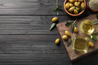 Düz kompozisyon ve siyah ahşap masa üzerinde zeytin yağı. Metin için boşluk