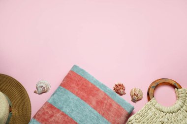 Plaj havlusu, hasır şapka ve pembe arka planda çanta, düz yatış. Metin için boşluk