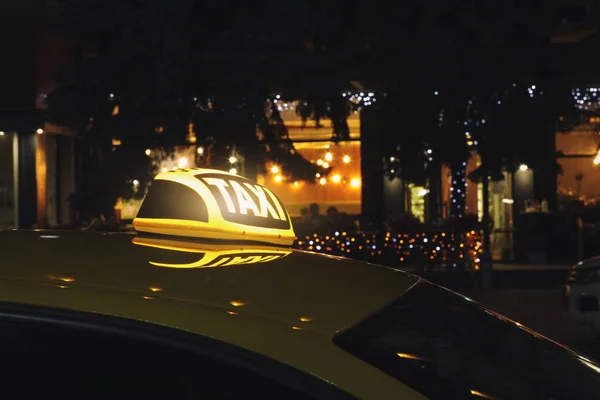 夜に街の通りに黄色の標識付きのタクシー車 — ストック写真