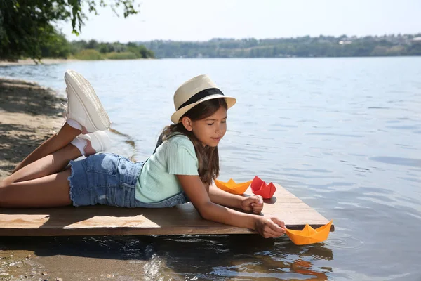 Aranyos Kislány Játszik Papírhajó Mólón Közel Folyóhoz — Stock Fotó