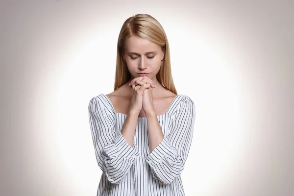 Religiös Ung Kvinna Med Knäppta Händer Mot Ljus Bakgrund — Stockfoto