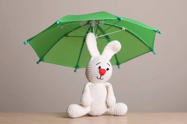 木制桌子上的小伞和玩具兔子 — 图库照片