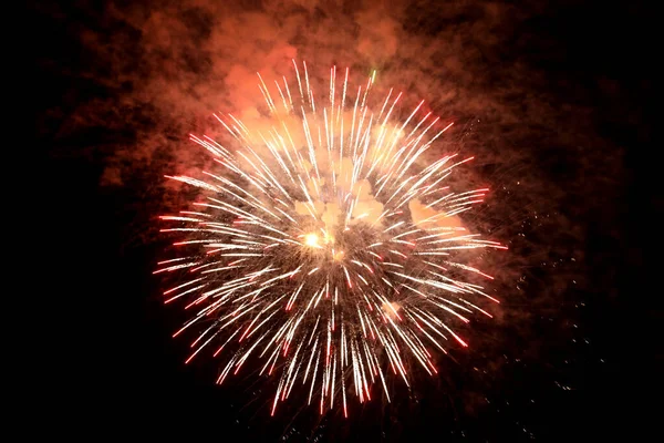 Güzel, parlak havai fişekler gece gökyüzünü aydınlatıyor.