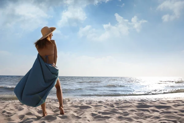 Kvinna Med Strandhandduk Och Halmhatt Sand Nära Havet Bakifrån Plats — Stockfoto