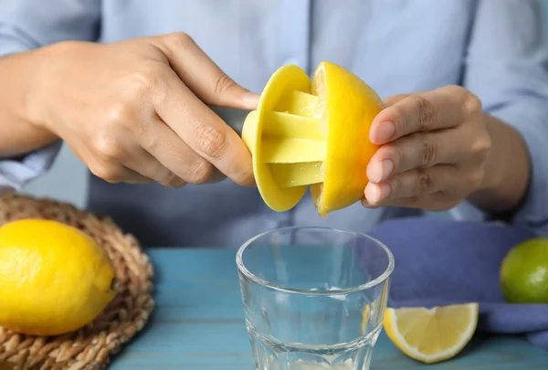 Kvinna Pressa Citronsaft Med Citrus Brotsch Vid Ljusblå Träbord Närbild — Stockfoto