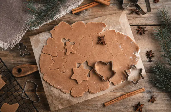 做圣诞饼干在木制桌子上用生面团和切割机铺成平整的构图 — 图库照片