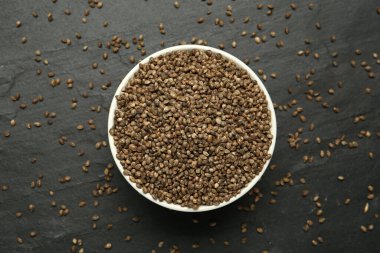 Siyah masa üzerinde chia tohumları olan seramik kase, düz. Mutfak aletleri