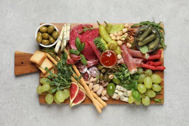 Açık gri masada servis edilen farklı lezzetli aperatifler.