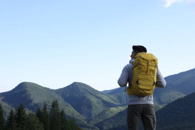 Sırt çantalı turist dağ manzarasının tadını çıkarıyor. Metin için boşluk