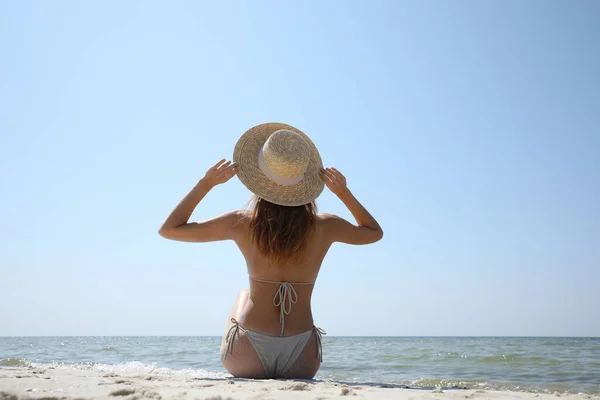 Vrouw Bikini Zittend Zandstrand Vlakbij Zee Achteraanzicht — Stockfoto