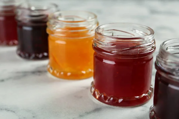 Gläser Mit Verschiedenen Marmeladen Auf Weißem Marmortisch Nahaufnahme — Stockfoto