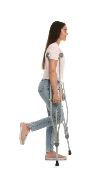 白い背景に葉腋のついた松葉杖を持つ若い女性 — ストック写真