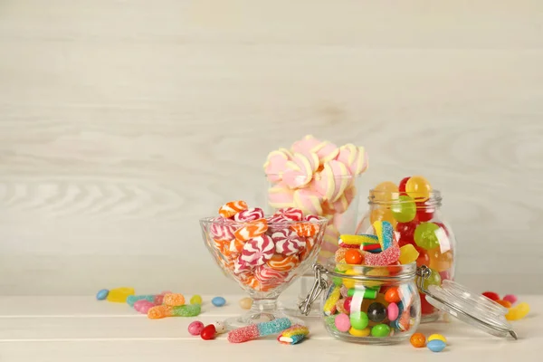 Üvegek Különböző Ízletes Cukorkák Bézs Asztalon Hely Szövegnek — Stock Fotó