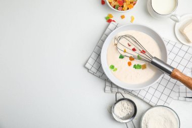Hamur hamuru, şekerli meyve ve diğer malzemelerle bembeyaz masa üzerinde düz kompozisyon, metin için boşluk