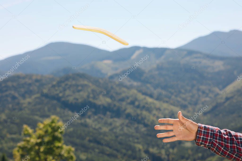 Man throwing boomerang in mountains, closeup view