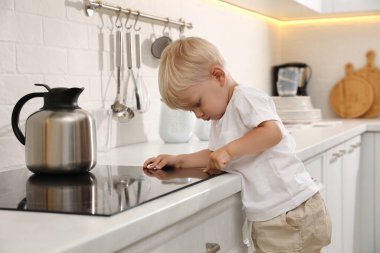 Mutfakta elektrikli sobayı keşfeden meraklı küçük çocuk.