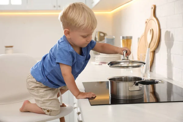 Любопытный Маленький Мальчик Играет Кастрюлей Электрической Плите Кухне — стоковое фото